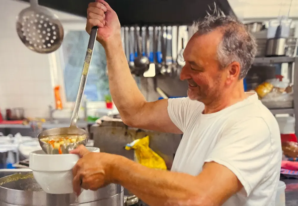 Uwe Bischoff beim servieren einer Suppe