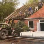 Historisches Bild vom Wiederaufbau mit Handwerkern auf dem Dach